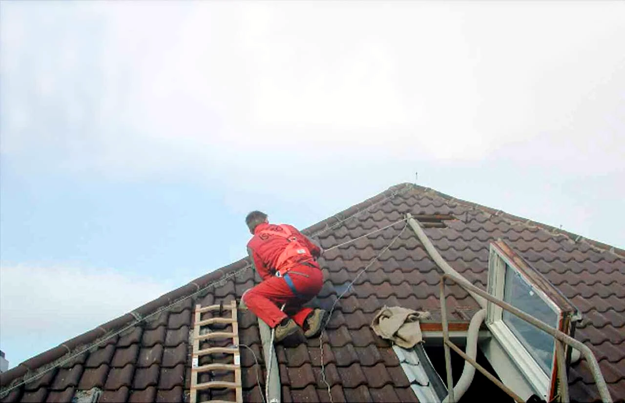 Dachdecker bei der Arbeit auf einem Ziegeldach